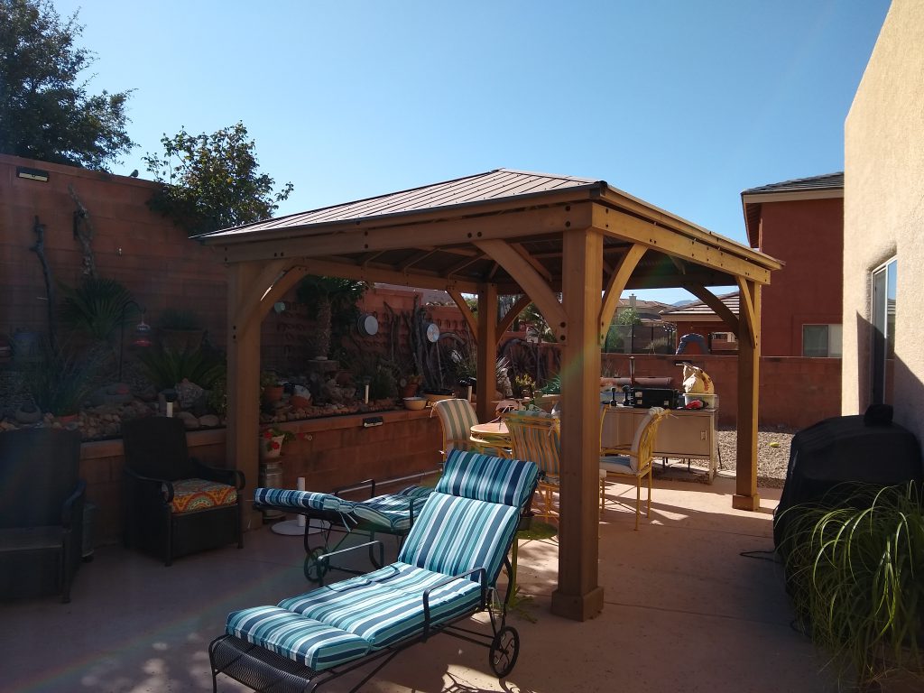 A pergola with a metal roof provides shade on an Arizona patio.