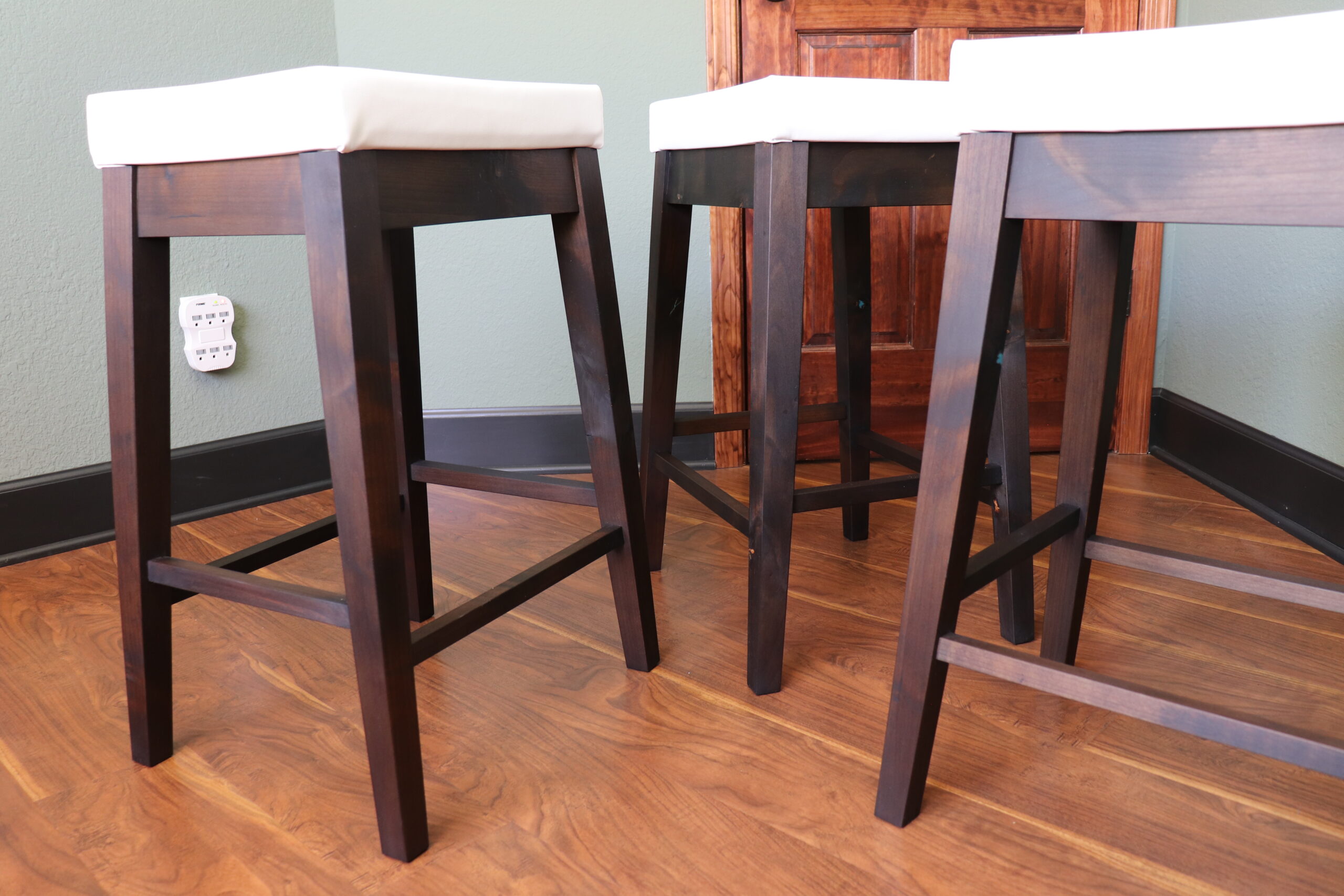 The ebonized finish contrasts nicely with the white upholstered cushions on these very comfortable stools.